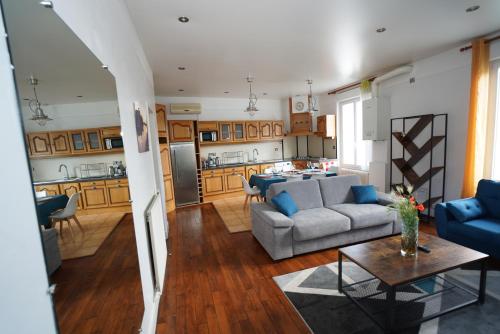 un salon et une cuisine avec un canapé et une table dans l'établissement Grand appart à 2 pas des bords de Loire, à Orléans