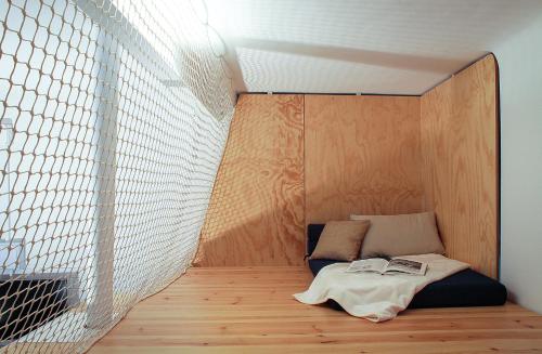 a small bed in a room with a wall at Casa Gall4 in Elche