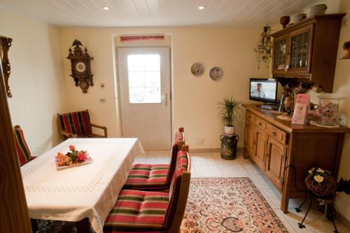 ein Esszimmer mit einem Tisch, Stühlen und einem TV in der Unterkunft Wein- und Sektgut Markus Hensler in Briedel