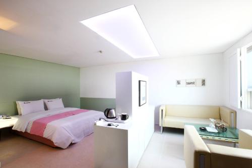 a bedroom with a large bed and a couch at Q Hotel in Paju