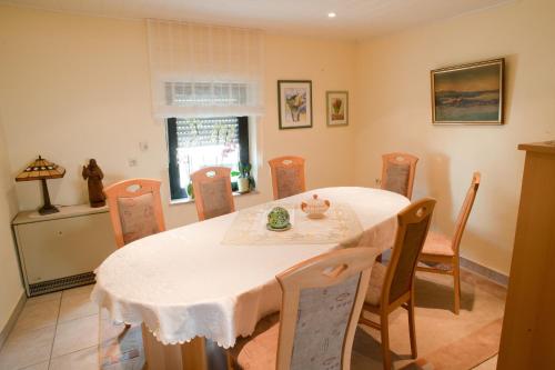 a dining room with a white table and chairs at Wein- und Sektgut Markus Hensler in Briedel
