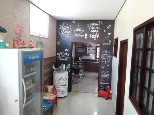 a kitchen with a black wall with writing on it at Pousada Flores em Vida in Olímpia