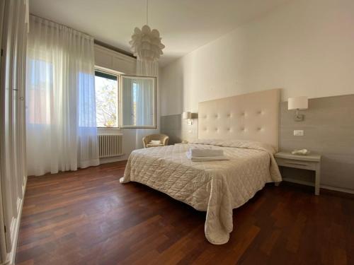 a bedroom with a large bed and a large window at Villa Alda Suites & Rooms in Cervia