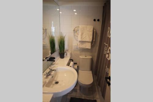 a white bathroom with a sink and a toilet at San Alfonso del Mar, Departamento 2D+2B, Kayak in Algarrobo