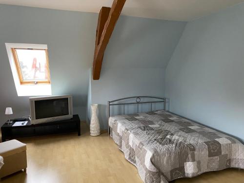 um quarto com uma cama e uma televisão de ecrã plano em Ferienwohnung „zur Sonne“ em Niederzimmern