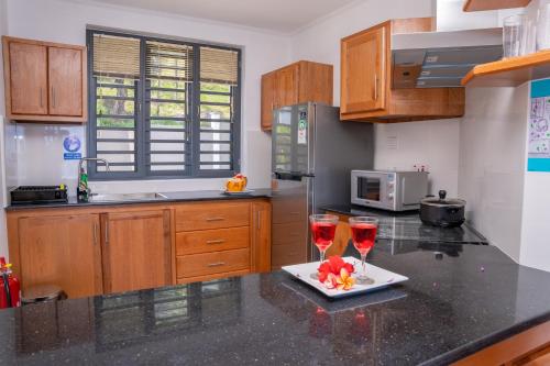 a kitchen with two glasses of wine on a counter at Kolibri Holiday Apartments in Victoria