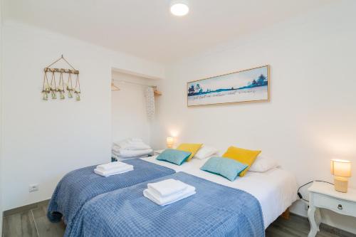 - 2 lits dans une chambre blanche avec des draps bleus dans l'établissement Casa do Loureiro 1 - Seia - Serra da Estrela, à Seia