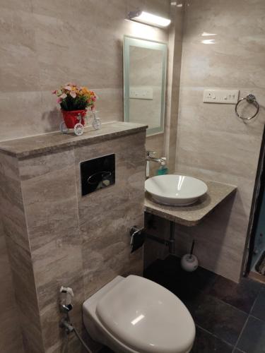 Areia De Goa Luxury Condo في آربورا: حمام به مرحاض أبيض ومغسلة