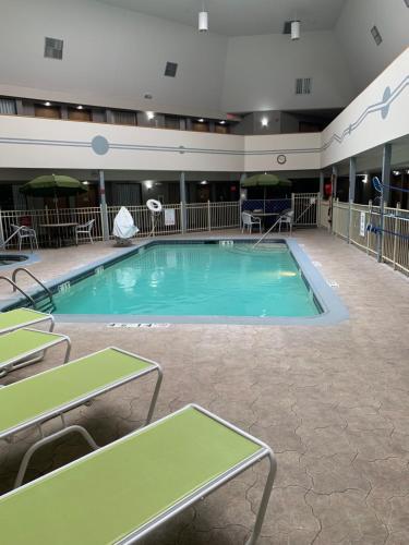 a large swimming pool in a hotel with tables and chairs at Wingate by Wyndham Brighton in Brighton