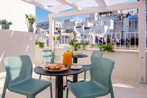 una mesa y sillas en un balcón con comida. en La Bella Ostuni Suites, en Ostuni