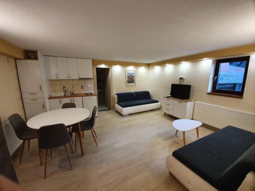 een kleine woonkamer met een tafel en een bank bij Marušić Apartments in Vlasic