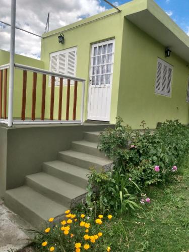 a house with stairs and flowers in front of it at Atardecer Serrano in Huerta Grande