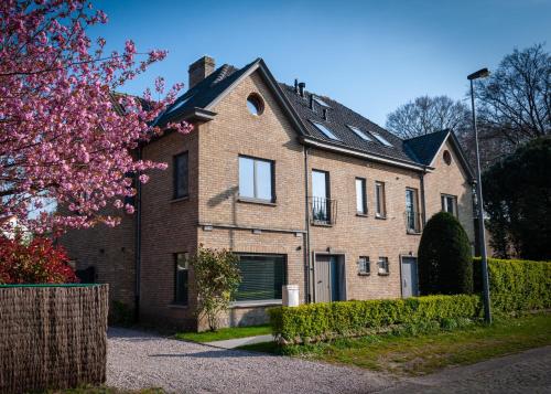 une grande maison en briques avec une clôture devant elle dans l'établissement Ten Hove Brugge, à Bruges