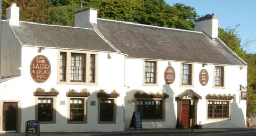 
a white and red building with a clock on the front of it at Laird And Dog Inn in Lasswade
