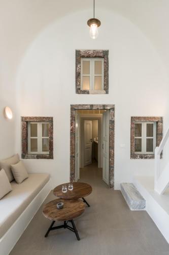 a living room with a white couch and a table at Enigma Suites in Fira