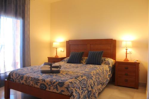 ミハス・コスタにあるResidencial Cala Azulのベッドルーム1室(ベッド1台、ナイトスタンド2台、ランプ2つ付)