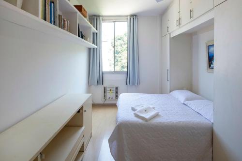 a small bedroom with a bed and a desk at Confortável e seguro 2 quartos com varanda no Leme in Rio de Janeiro