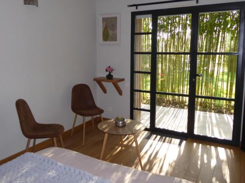 a bedroom with a bed and a sliding glass door at Le bois du drillais in La Gaubretière