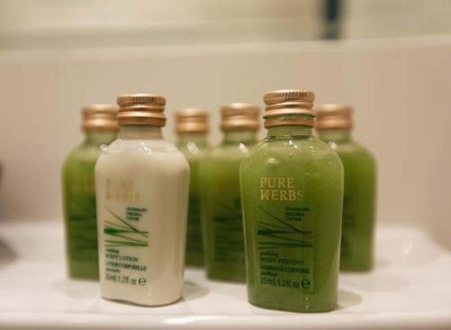 a group of four bottles of green liquid on a counter at Ahorn Hotel in Munich
