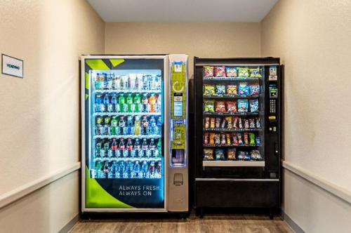 a soda machine in a room next to a refrigerator at WoodSpring Suites Dallas Rockwall in Rockwall