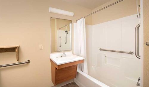 a white bathroom with a sink and a shower at WoodSpring Suites Dallas Rockwall in Rockwall