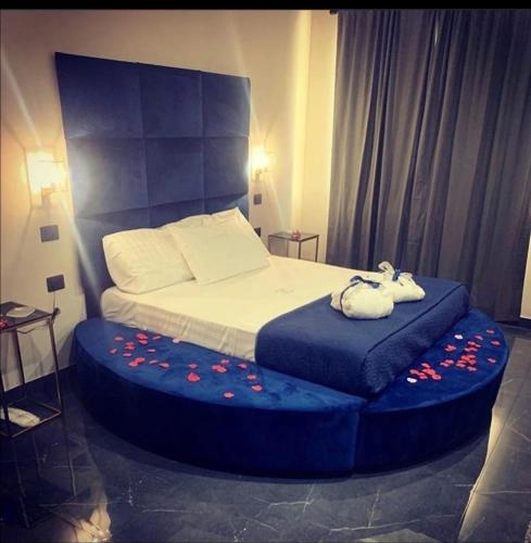 a bedroom with a bed with a blue ottoman at Hotel Elite in Varcaturo