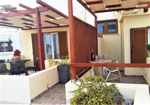 an outdoor patio with a pergola and a table at Pefkakia Park in Ermoupoli