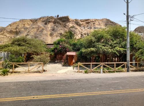 a building on the side of a road with a mountain at Villa Mistika in Zorritos
