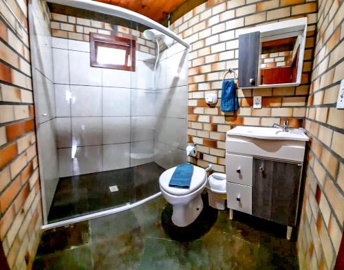 a small bathroom with a toilet and a shower at Pousada Raízes da Guarda in Guarda do Embaú