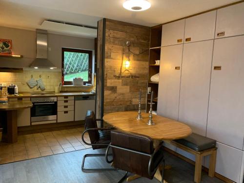 a kitchen with a wooden table and some chairs at Winterberger Lodge in Winterberg