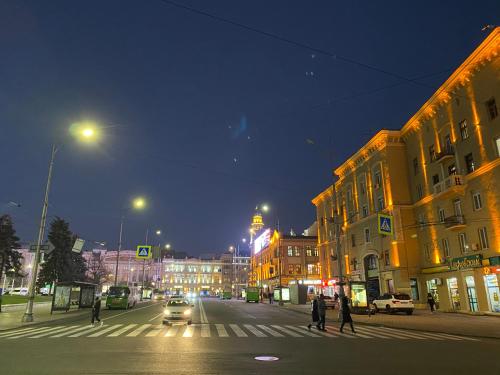a city street at night with people crossing the street at New luxury Apartment in the Center on Konstitution Square in Kharkiv