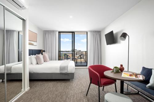 Pokój hotelowy z łóżkiem, stołem i kanapą w obiekcie Quest Preston w Melbourne