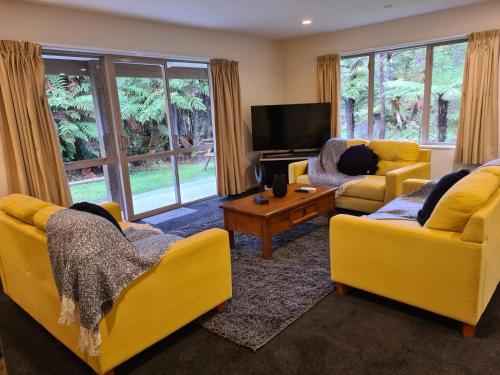 a living room filled with furniture and a tv at Rainforest Retreat in Franz Josef