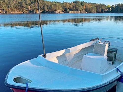 a blue boat sitting on the water on a lake at 6 person holiday home in HOSTELAND in Hosteland