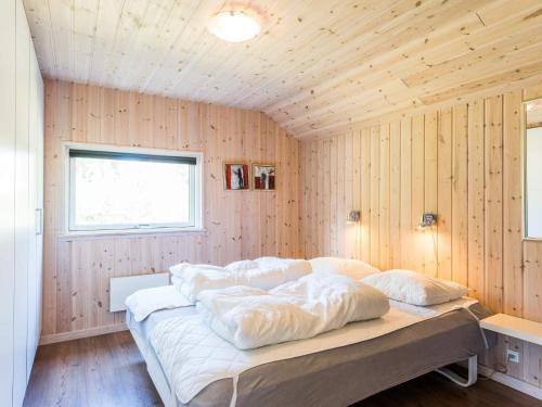 um quarto com paredes de madeira e uma cama com almofadas em Holiday home Blåvand CCXXXV em Blåvand