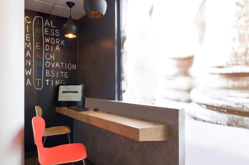 a desk and a red chair in a room at ibis Bordeaux Centre - Gare Saint-Jean in Bordeaux