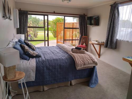 ein Schlafzimmer mit einem Bett und einem großen Fenster in der Unterkunft Carters Beach Bed and Breakfast in Westport