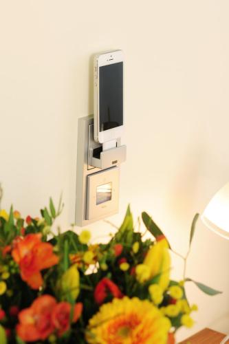 a vase of flowers sitting next to a tv at GuestHouse Mainz in Mainz