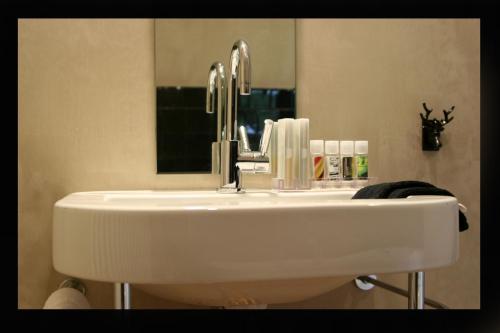 a white sink in a bathroom with a mirror at B&B AubergInn in Tessenderlo