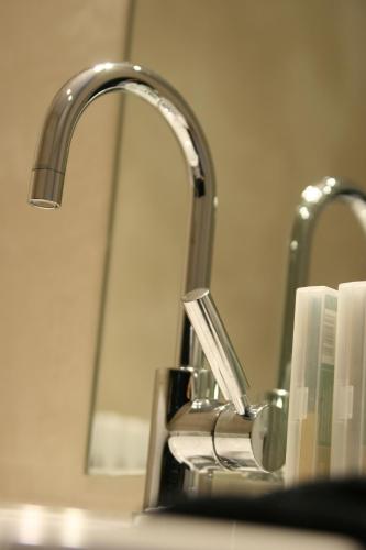 a bathroom sink with a toothbrush holder next to a faucet at B&B AubergInn in Tessenderlo