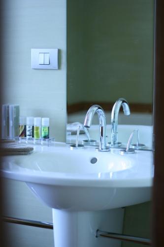 a white sink in a bathroom with a mirror at B&B AubergInn in Tessenderlo