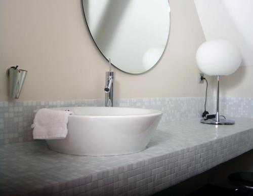 a bathroom with a white sink and a mirror at B&B AubergInn in Tessenderlo