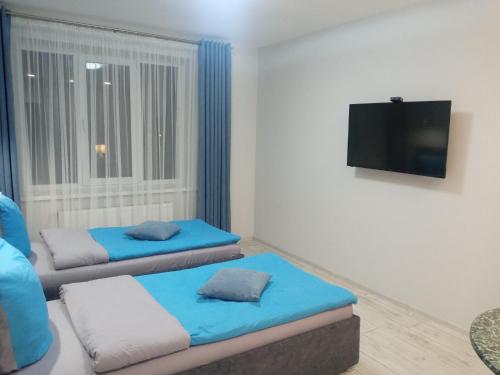 ein Wohnzimmer mit 2 Betten und einem Flachbild-TV in der Unterkunft Апартаменты Weekend Inn in Uschhorod