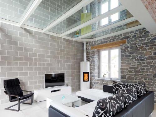 un soggiorno con divano, TV e muro di mattoni di Classy Holiday Home in Achet with Garden 