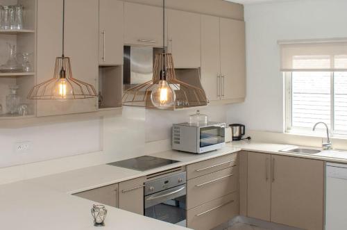 a kitchen with white cabinets and a microwave at Exclusive penthouse with paradise sea view in Grand-Baie