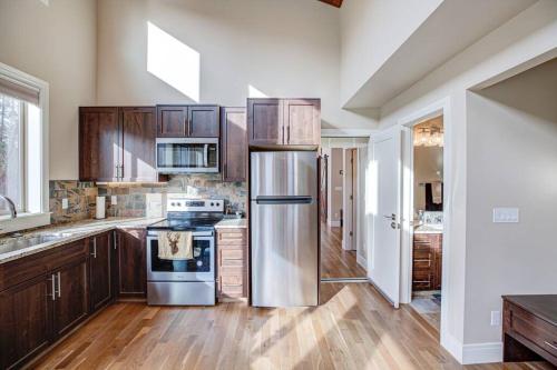 a kitchen with wooden cabinets and a stainless steel refrigerator at Newly built Modern Chalet Duplex - 2 in Mount Hood Village