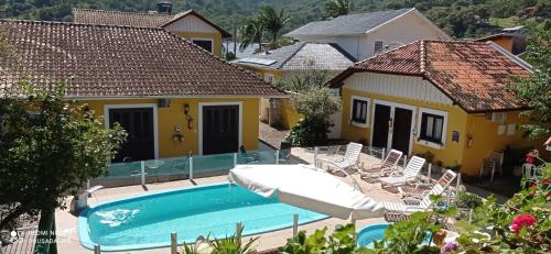 Villa con piscina frente a una casa en Pousada Jardim Porto Belo en Porto Belo