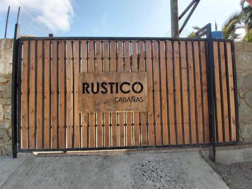 a gate with a rustico casitas sign on it at Cabañas RUSTICOPAPUDO in Papudo