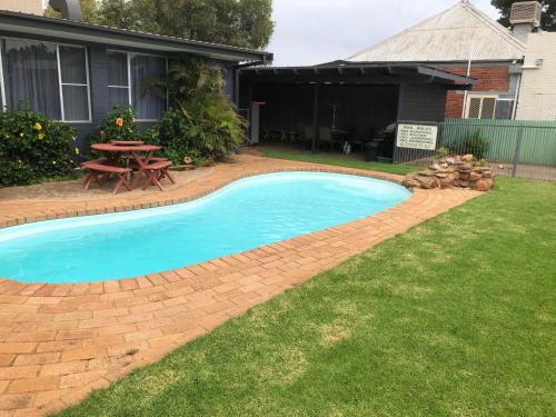 a swimming pool in a yard with a picnic table at Memphis Motor Inn in Parkes