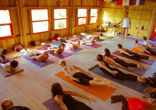 un grupo de personas haciendo yoga en una habitación en Hus Punta Rubia, en La Pedrera